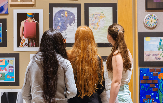 image of students looking at art in the Community Corridor