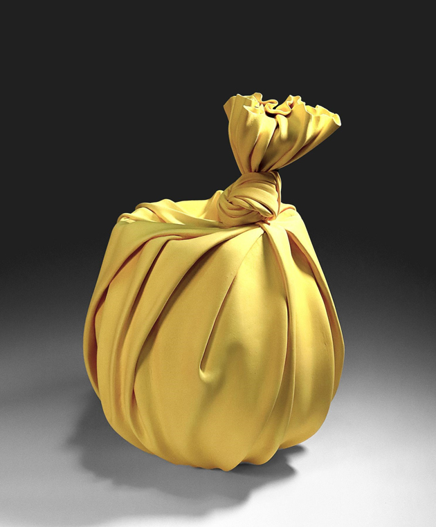 Light ochre stoneware sculpture fashioned with the appearance of being wrapped around an object and knotted at the top'